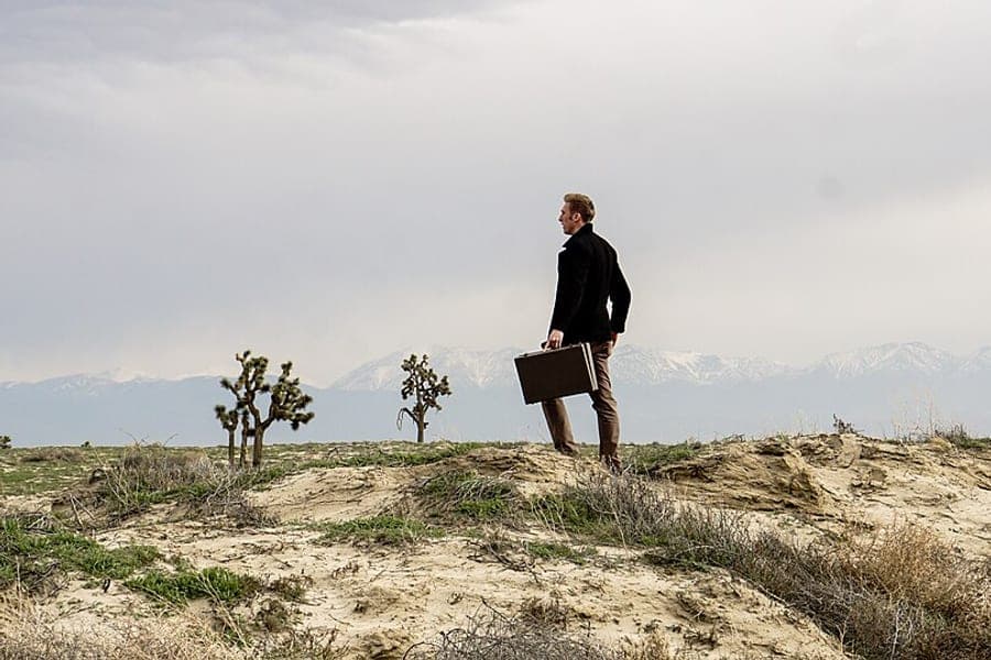 A traveler stepping out with a rolling suitcase