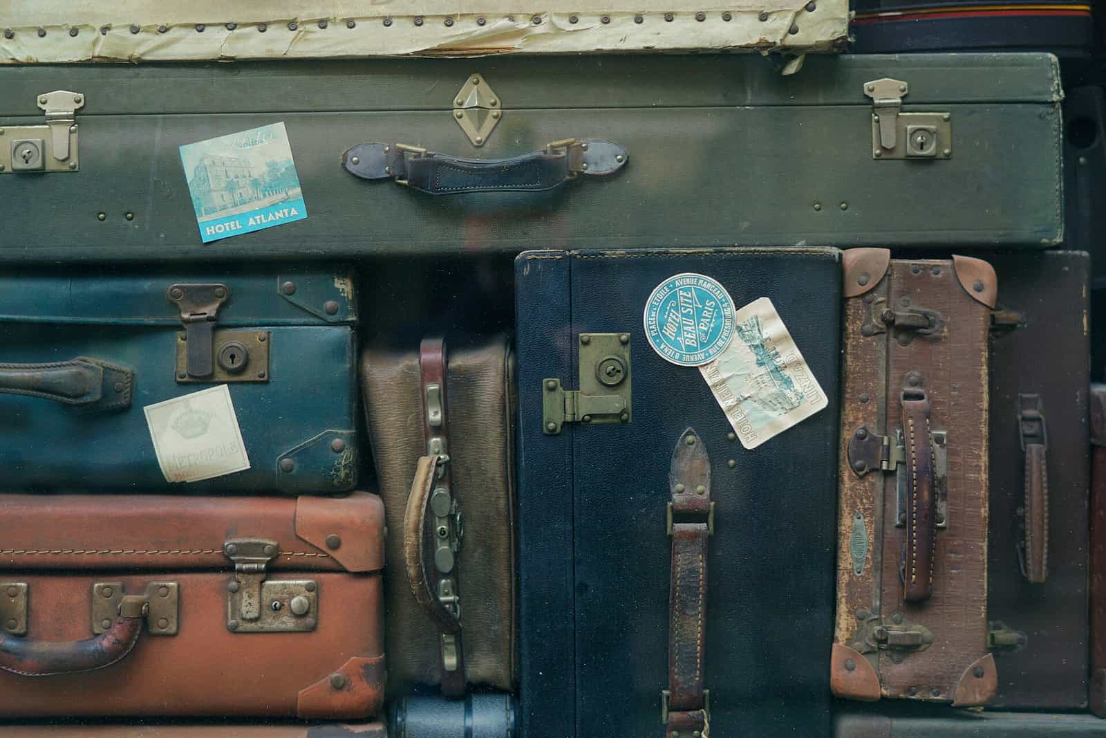 A stack of soft and hard suitcases waiting to be loaded
