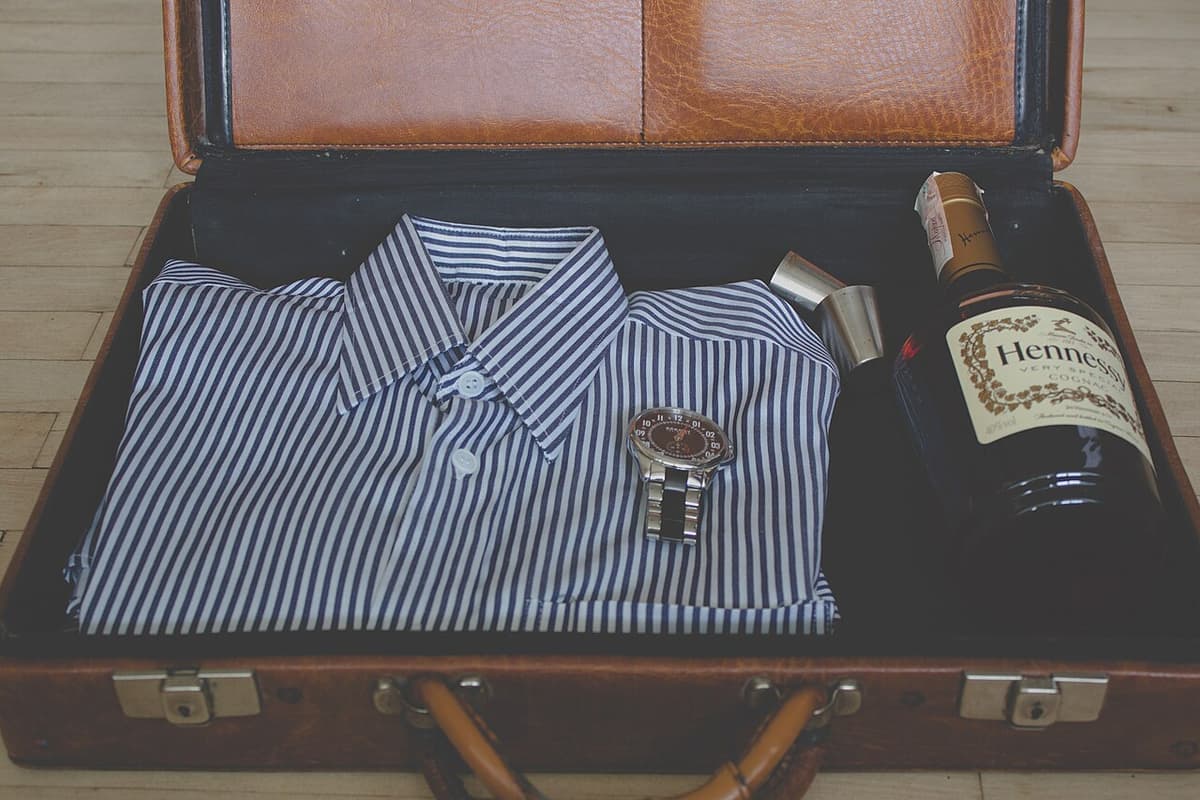 Clothes and travel items laid out beside an open suitcase